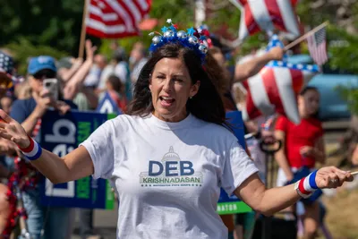 Washington State Senate candidate Deb Krishnadasan greets the crowd during the Fourth of July parade in Home, Washington.